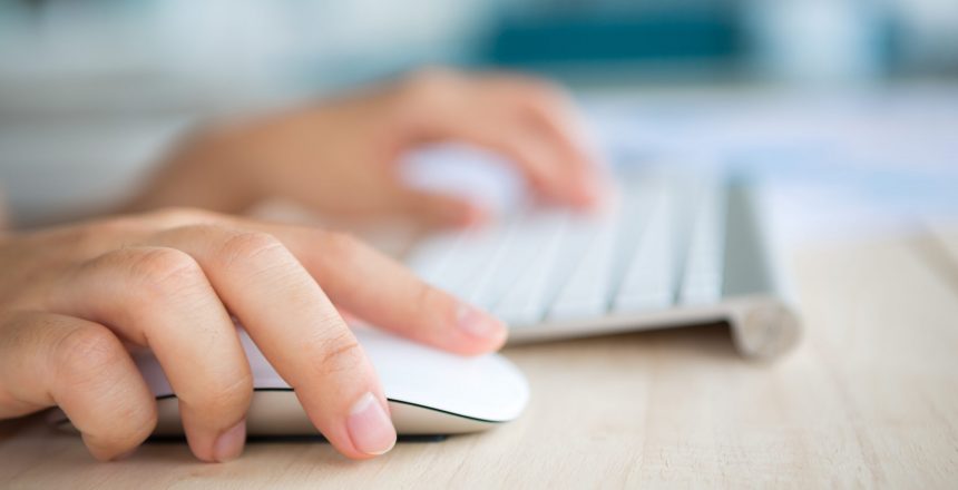 Closeup of business woman hand typing on keyboard and mouse